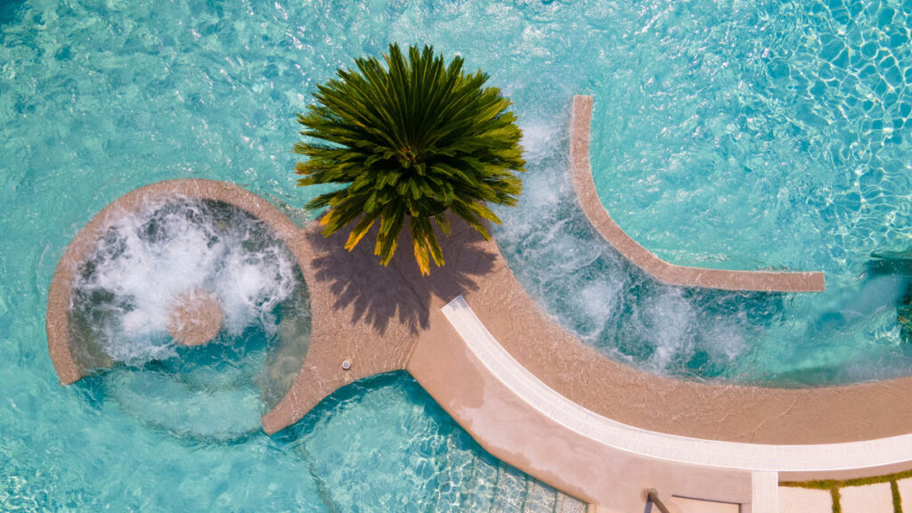 Vista dall'alto della zona idromassaggio e della palma centrale nella piscina dell'Hotel Terme Quisisana.