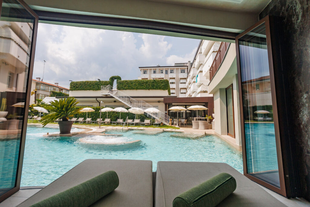 Dettaglio delle fontane d'acqua nella piscina esterna dell'hotel, con vista sulla zona relax.