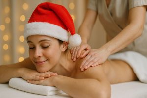 Ragazza con cappello da Babbo Natale che si fa fare un massaggio