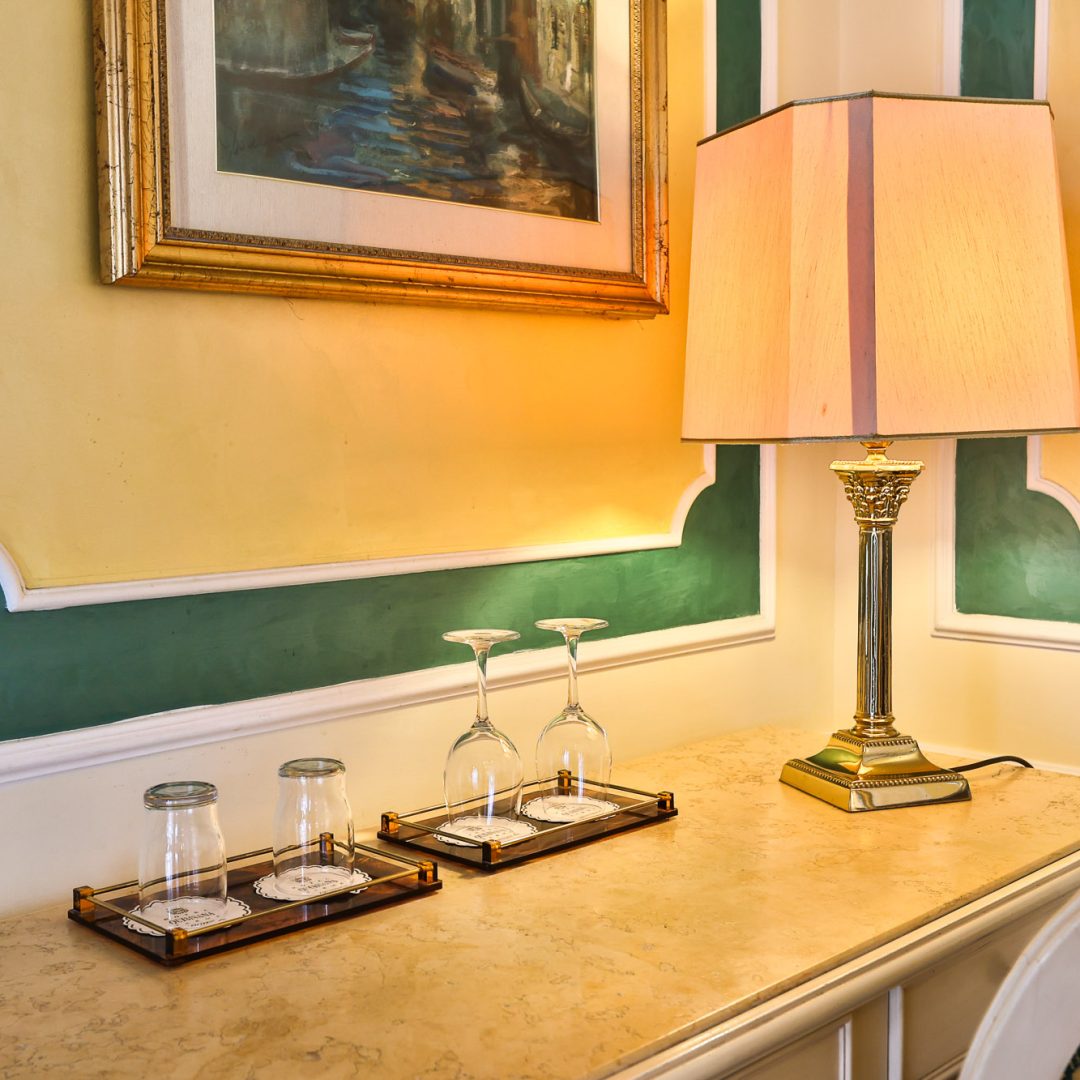Salotto nella Suite Atena con divano elegante e tappeto pregiato.