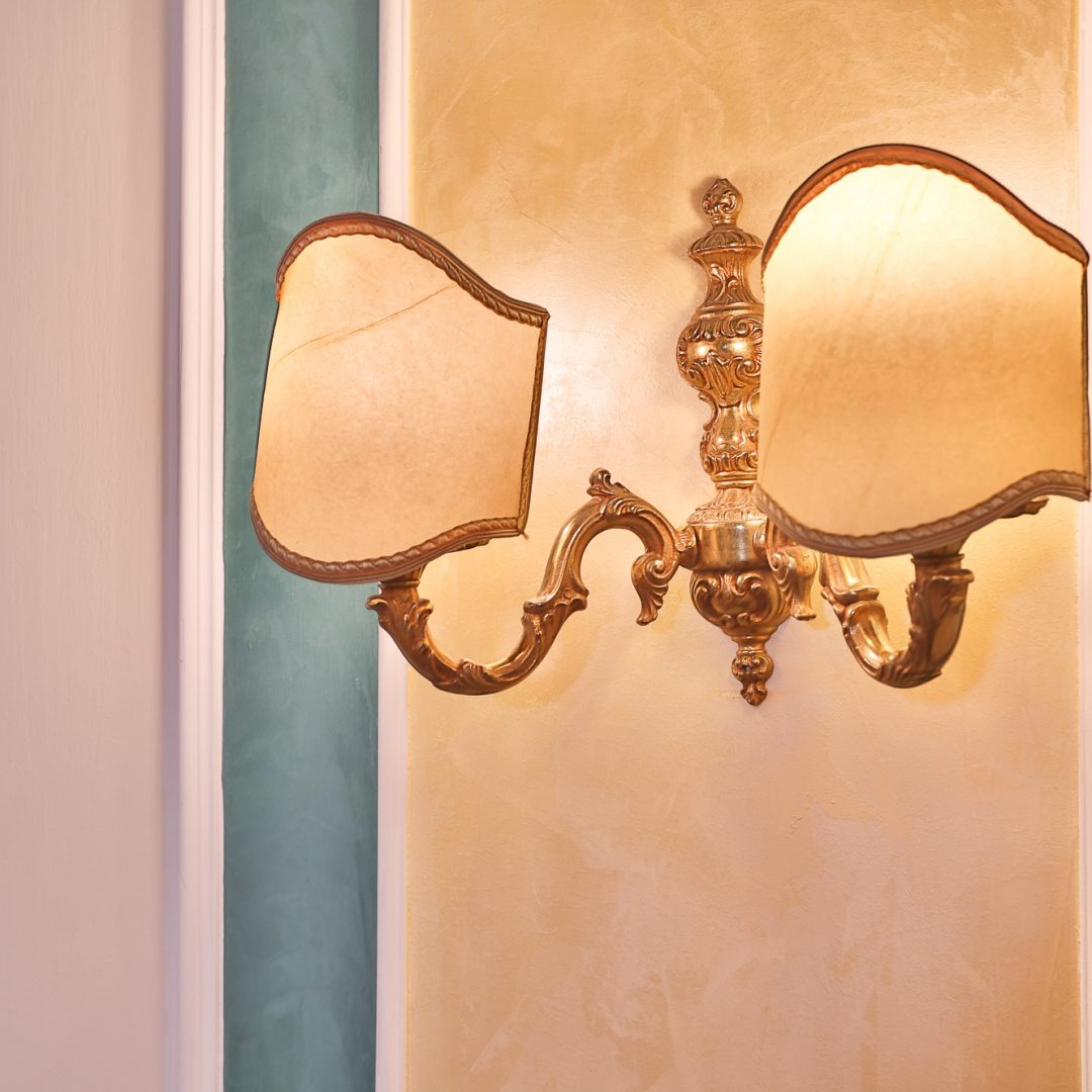 Applique dorata nella Suite Atena con paralume decorativo