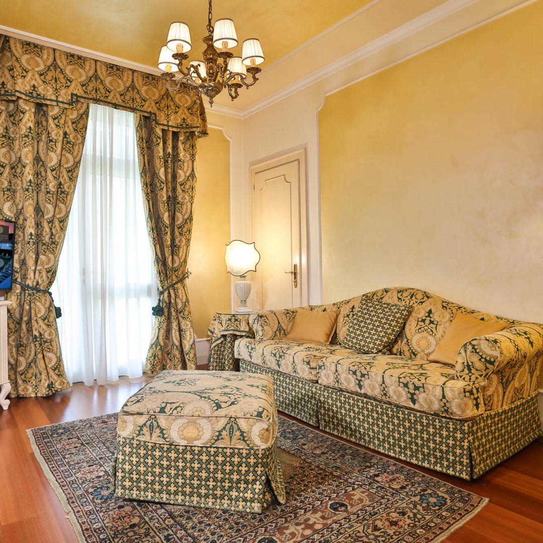 Salotto della Suite Atena con arredi classici e tessuti raffinati.