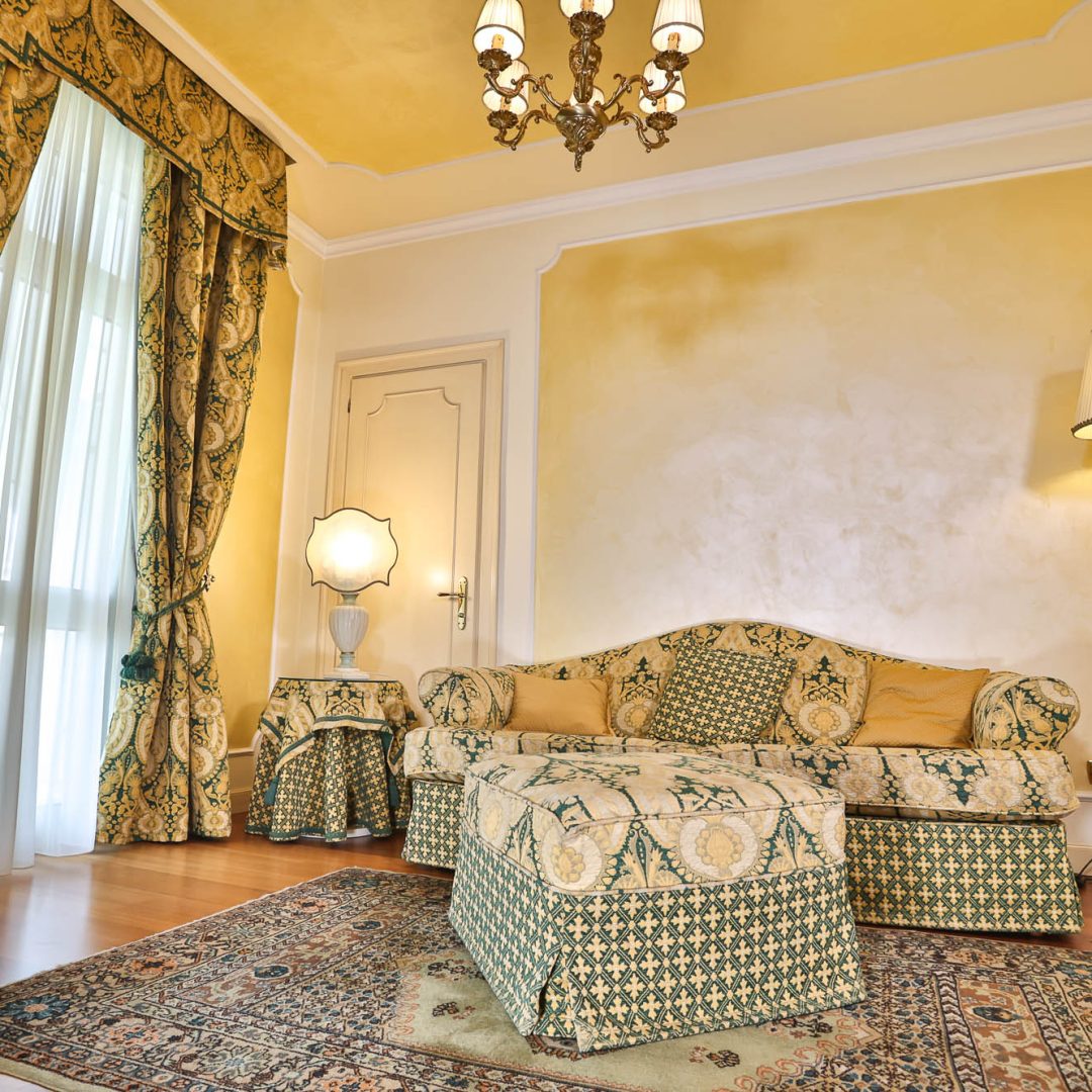 Camera da letto della Suite Atena con letto matrimoniale e affreschi artistici.