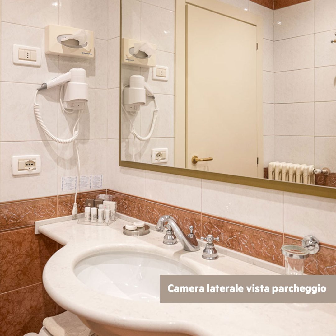 Bagno elegante con lavabo in marmo e rubinetteria cromata.
