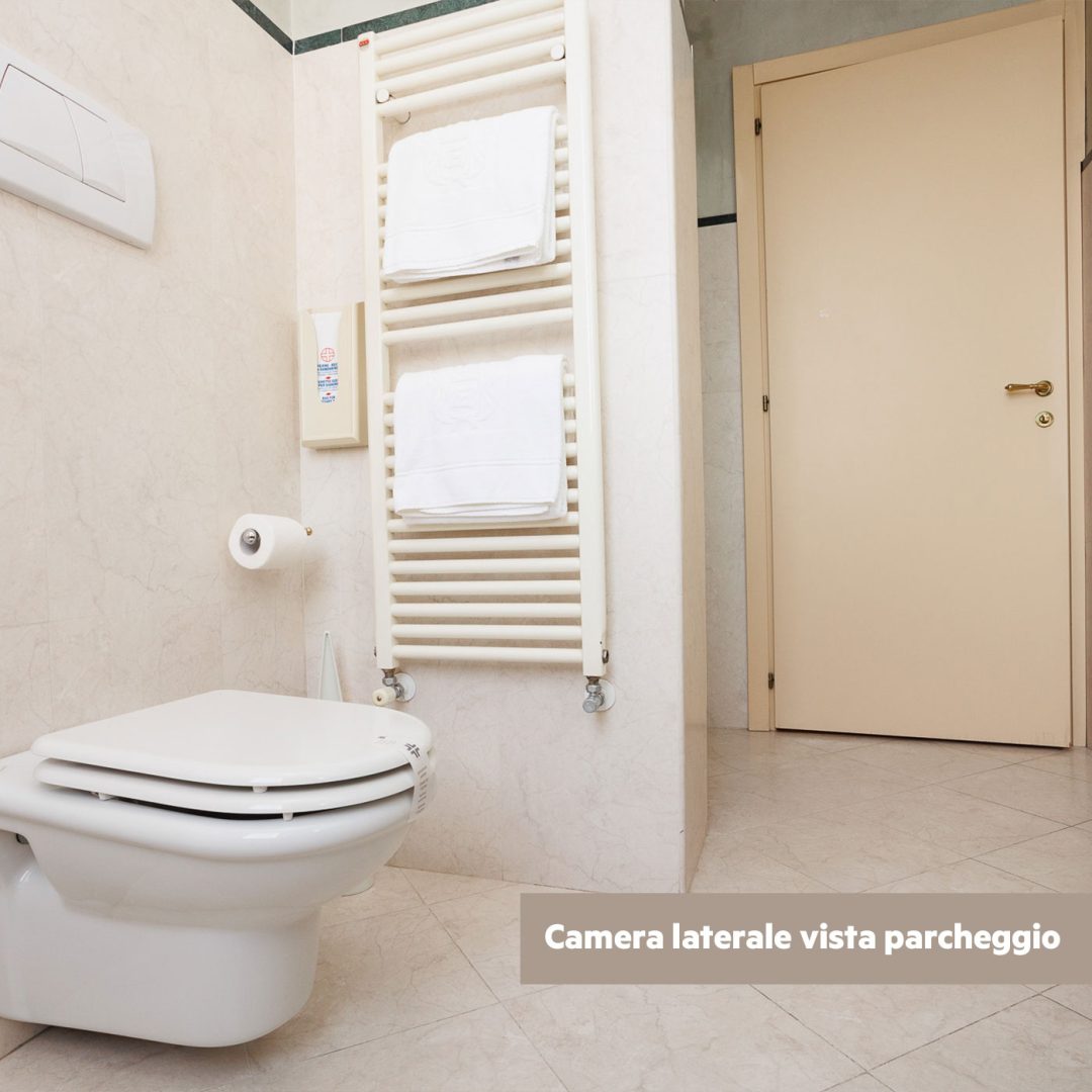 WC con scalda salviette e pareti in marmo chiaro.