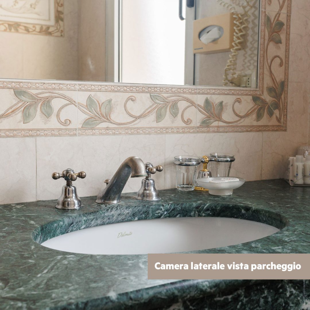 Bagno della camera Superior lato piscina con termoarredo e scultura decorativa.