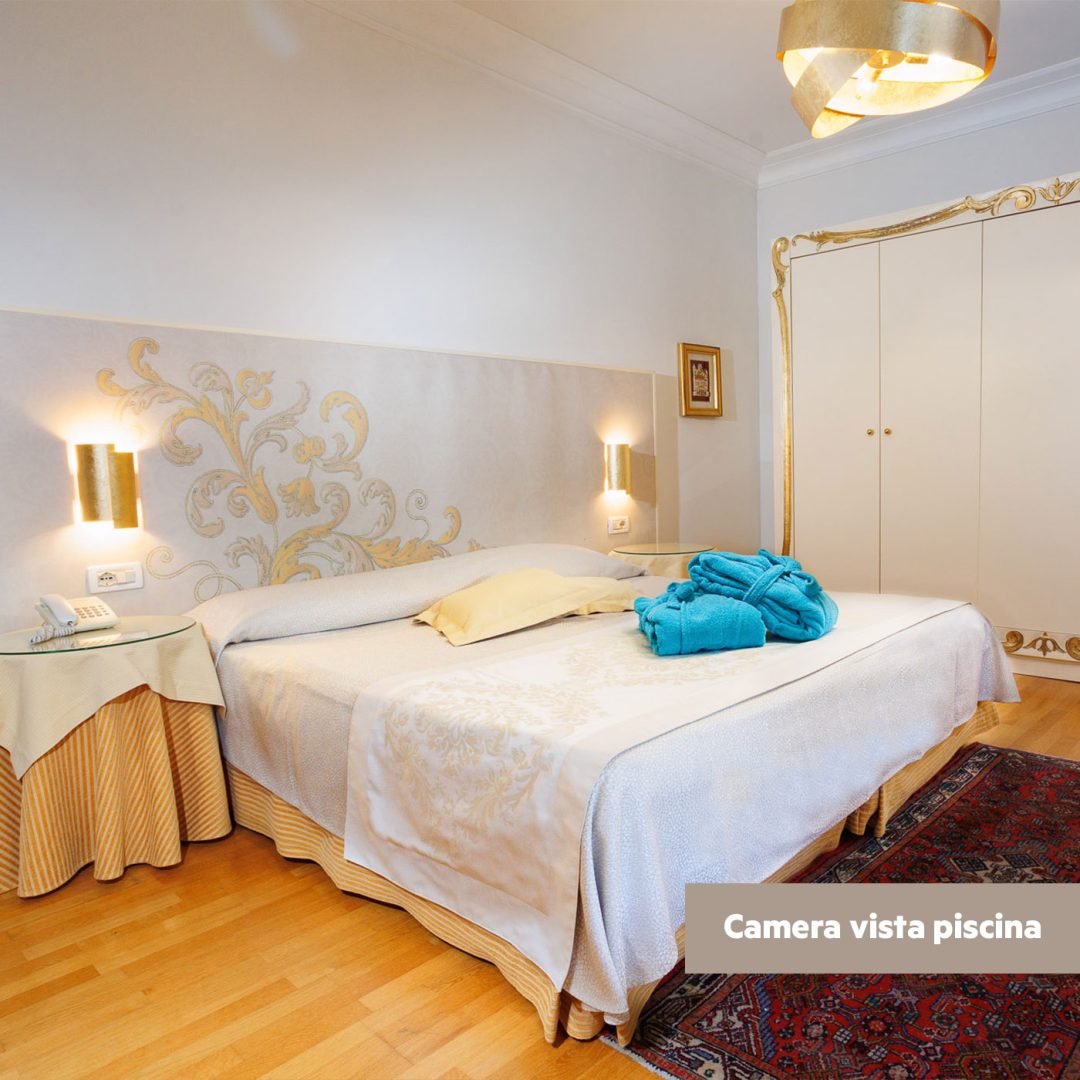 Vista panoramica della camera Superior lato piscina con armadio, letto matrimoniale e dettagli eleganti.