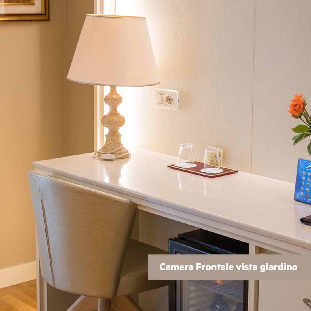 Angolo relax della camera superior con sedia e minibar.
